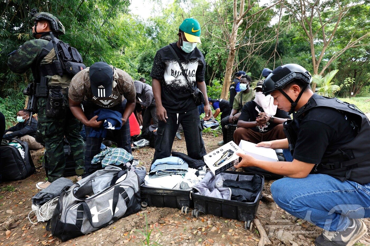 본문 이미지 -  24일&#40;현지시간&#41; 태국 딱주 매솟 지역에서 태국 공무원이 미얀마 KK 파크 단지에서 일하다 모에이 강을 통해 태국으로 넘어온 한 남성의 소지품을 검사하고 있다. 2025.10.24. ⓒ AFP=뉴스1 ⓒ News1 이정환 기자