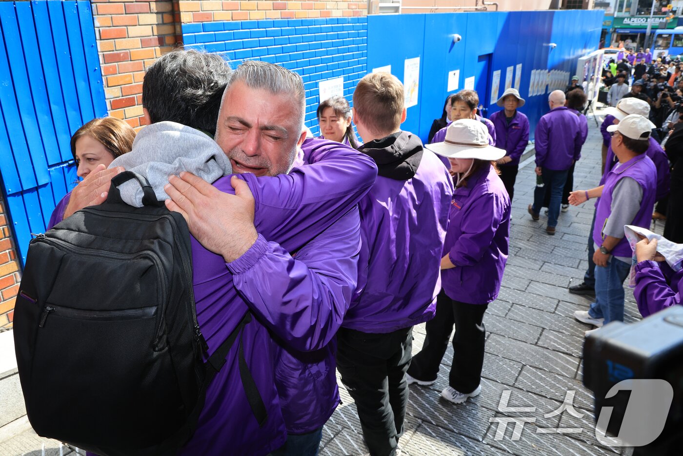 본문 이미지 - 이태원 참사 3주기를 앞둔 25일 서울 용산구 이태원역 1번 출구 앞 ‘10.29 기억과 안전의 길'을 찾은 외국인 희생자 유가족들이 슬픔에 잠겨 있다. 2025.10.25/뉴스1 ⓒ News1 이호윤 기자