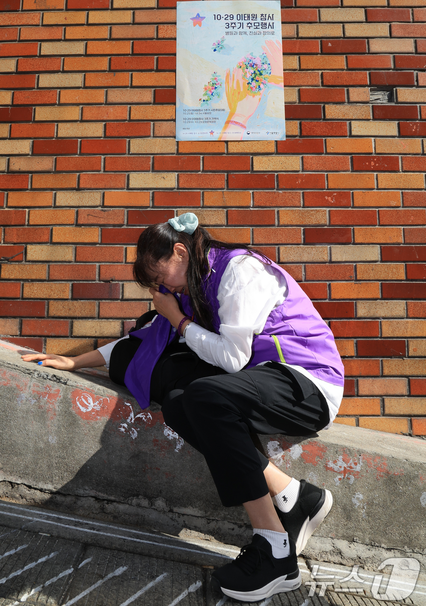 (서울=뉴스1) 이호윤 기자 = 이태원 참사 3주기를 앞둔 25일 서울 용산구 이태원역 1번 출구 앞 ‘10.29 기억과 안전의 길'을 찾은 외국인 희생자 유가족이 슬픔에 잠겨 있 …