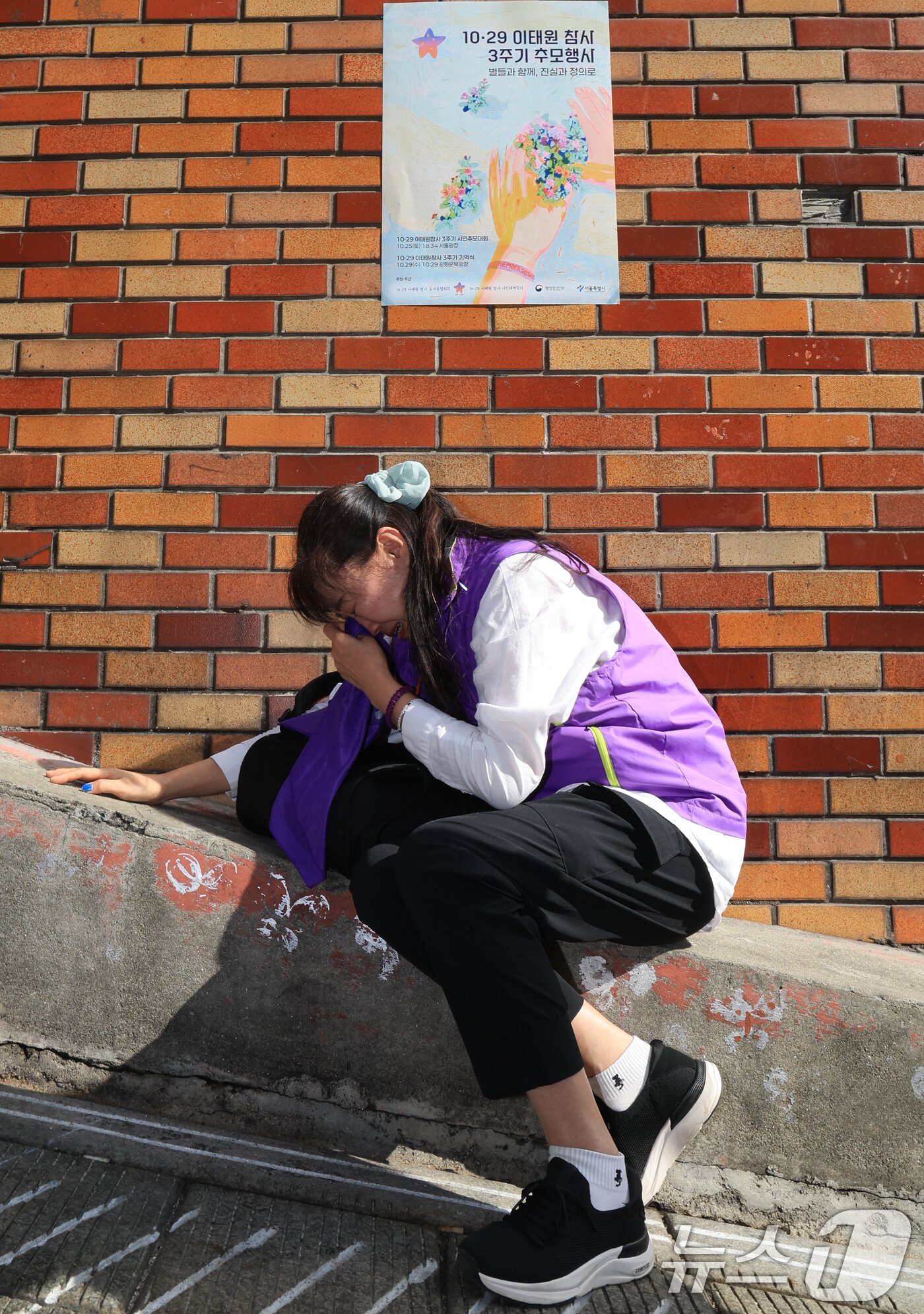 본문 이미지 - 이태원 참사 3주기를 앞둔 25일 서울 용산구 이태원역 1번 출구 앞 ‘10.29 기억과 안전의 길&#39;을 찾은 외국인 희생자 유가족이 슬픔에 잠겨 있다. 2025.10.25/뉴스1 ⓒ News1 이호윤 기자