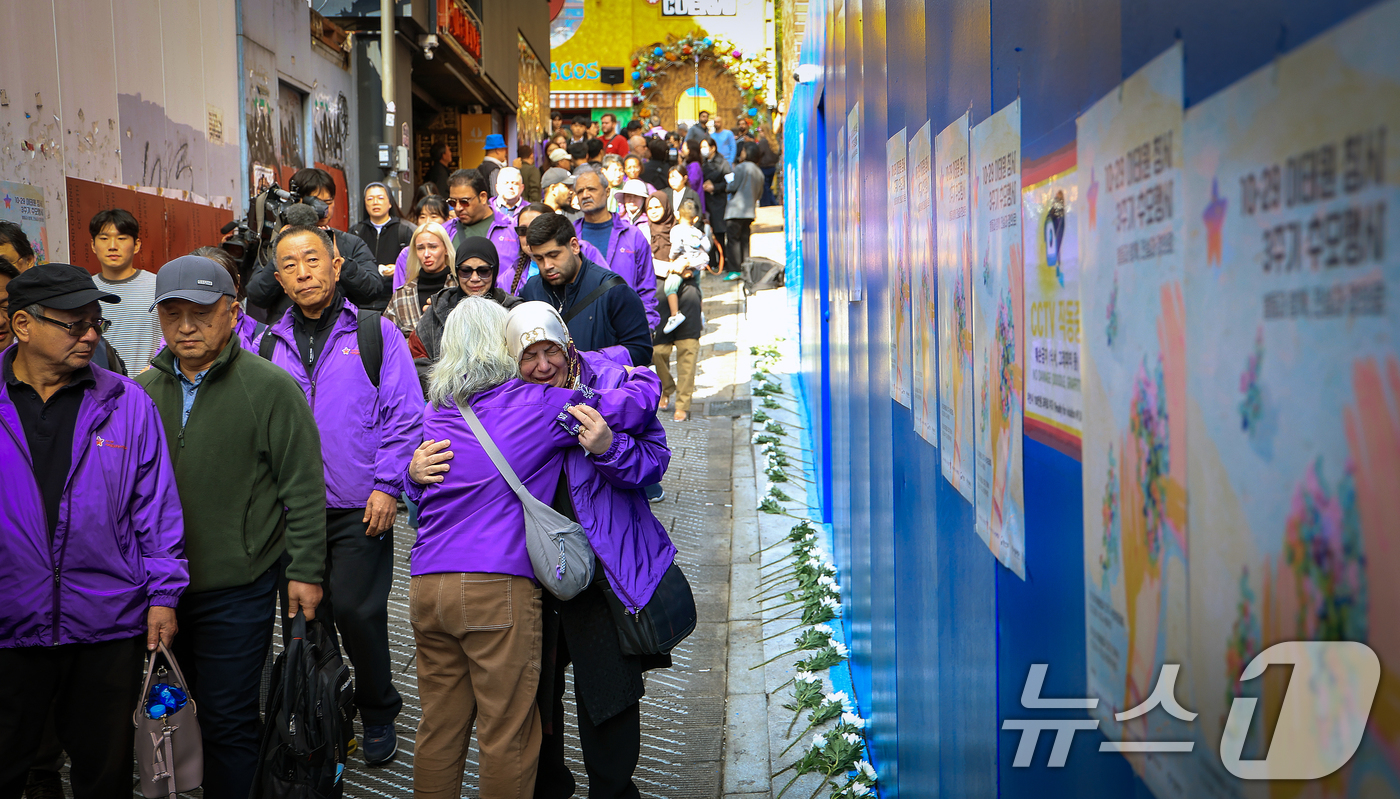 (서울=뉴스1) 이호윤 기자 = 이태원 참사 3주기를 앞둔 25일 서울 용산구 이태원역 1번 출구 앞 ‘10.29 기억과 안전의 길'을 찾은 외국인 희생자 유가족들이 슬픔에 잠겨 …