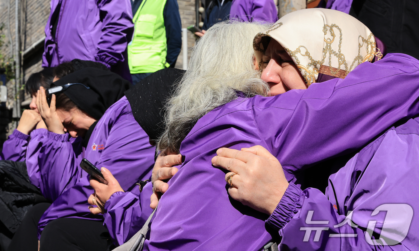 (서울=뉴스1) 이호윤 기자 = 이태원 참사 3주기를 앞둔 25일 서울 용산구 이태원역 1번 출구 앞 ‘10.29 기억과 안전의 길'을 찾은 외국인 희생자 유가족들이 슬픔에 잠겨 …