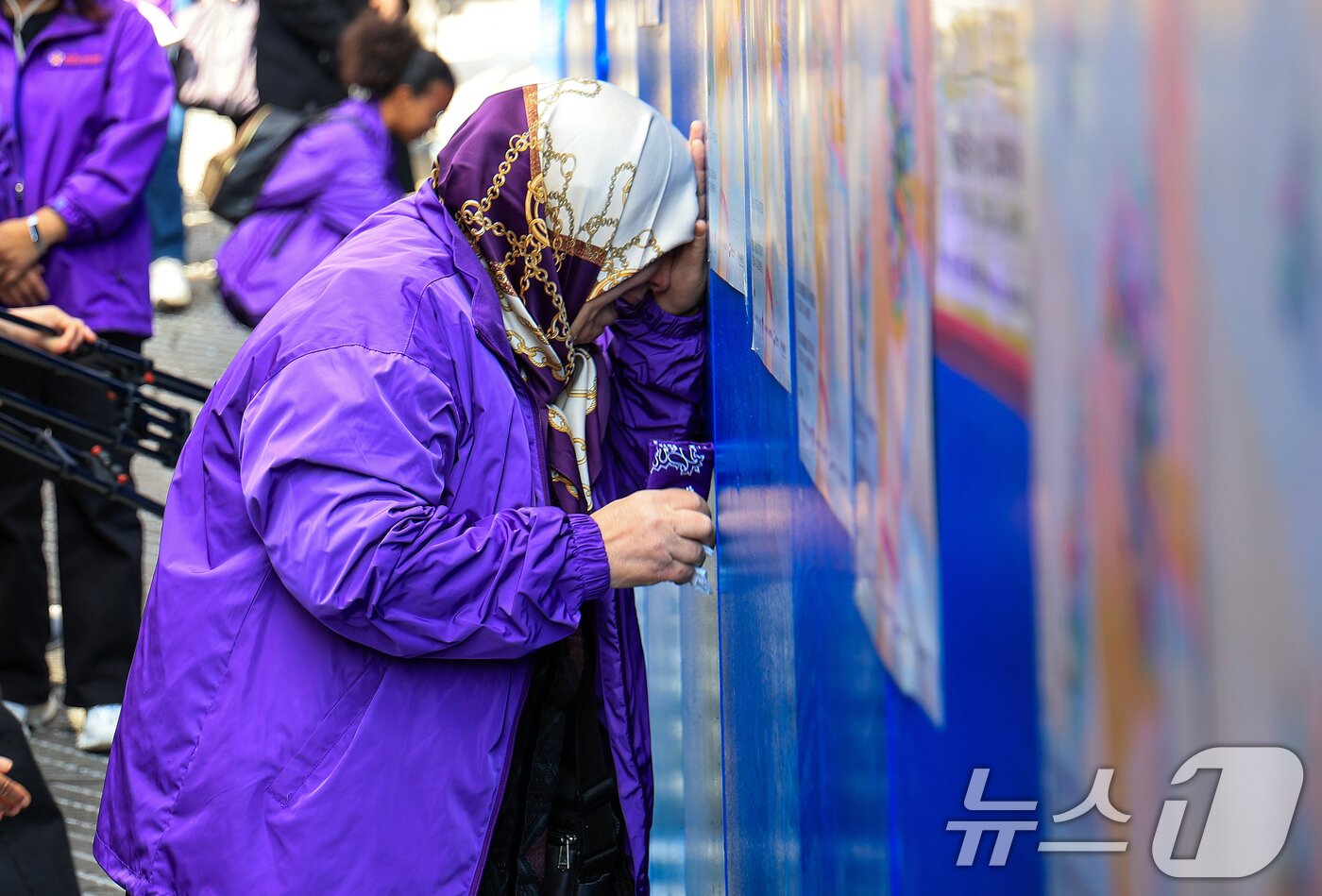 본문 이미지 - 이태원 참사 3주기를 앞둔 25일 서울 용산구 이태원역 1번 출구 앞 ‘10.29 기억과 안전의 길'을 찾은 외국인 희생자 유가족들이 슬픔에 잠겨 있다. 2025.10.25/뉴스1 ⓒ News1 이호윤 기자