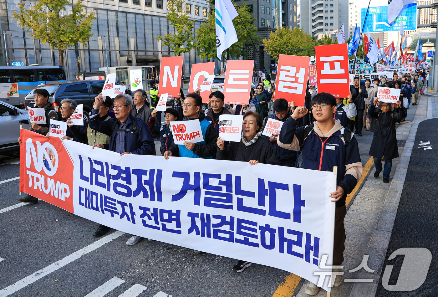 (서울=뉴스1) 이호윤 기자 = 트럼프저지공동행동 회원들이 25일 서울 중구 세종대로에서 열린 대미투자 전면 재검토 NO 트럼프 범시민대행진에 참가해  피켓을 들고 행진하고 있다. …