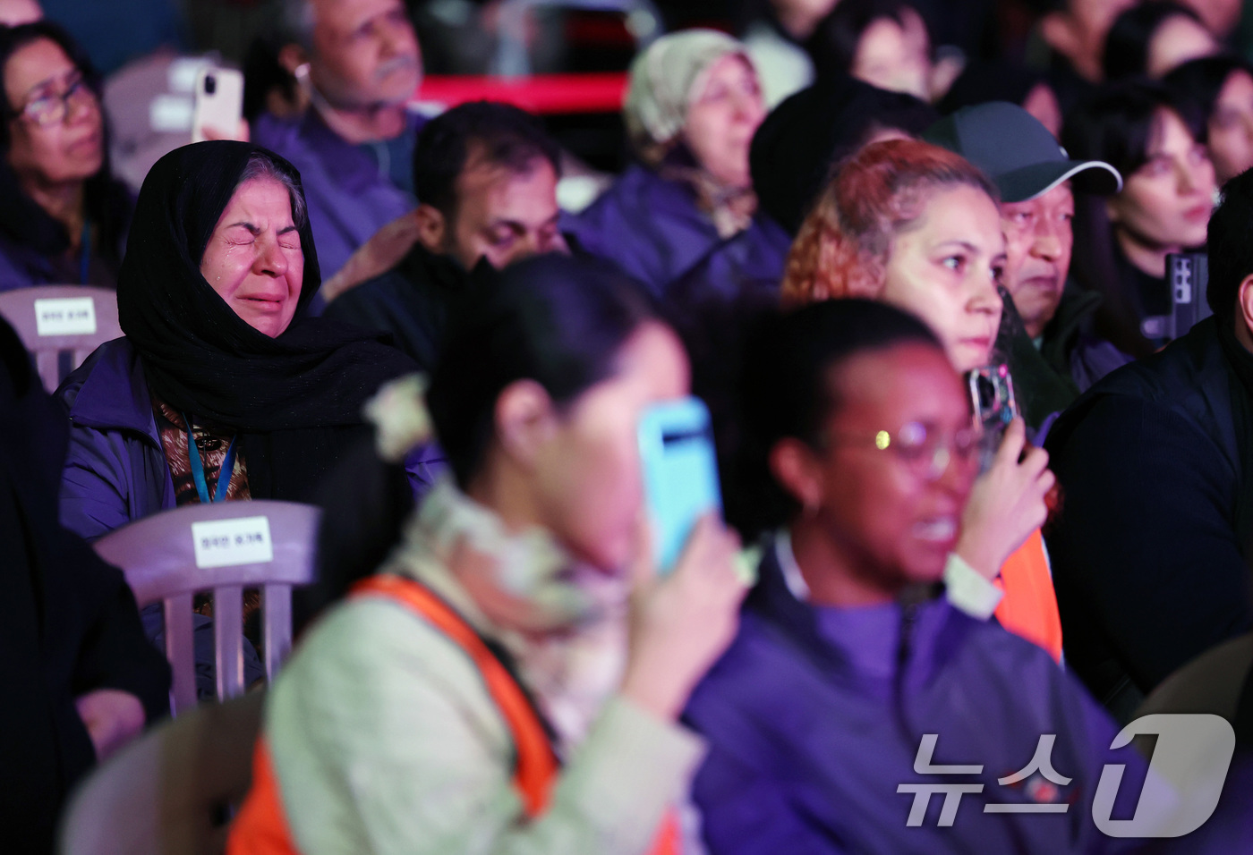 (서울=뉴스1) 이호윤 기자 = 25일 서울 중구 서울광장에서 열린 이태원 참사 3주기 시민추모대회에서 외국인 희생자 유가족들이 희생자 호명식 영상을 보고 있다. (공동취재) 20 …