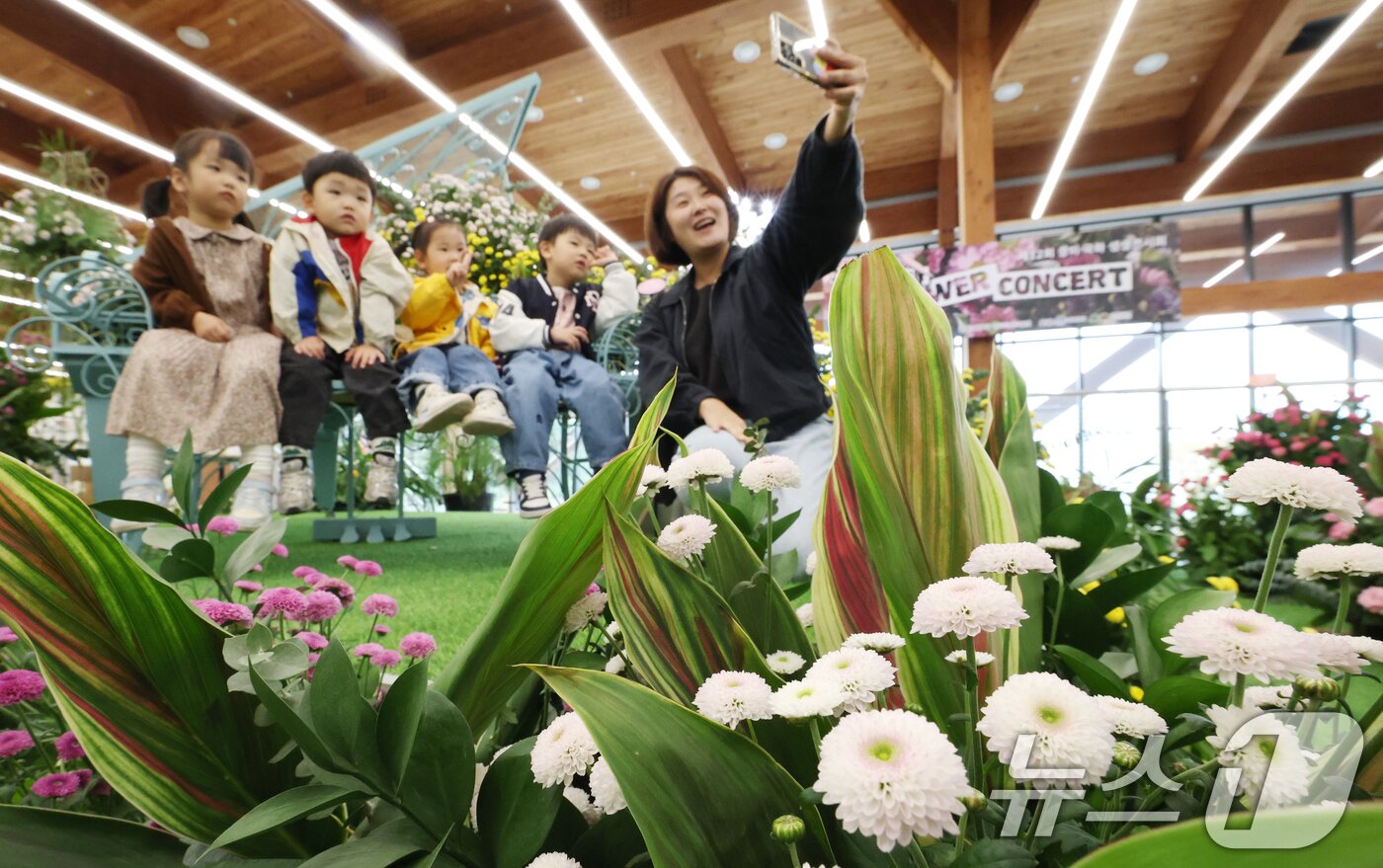 본문 이미지 - 26일 경기 수원시 영통구 영흥수목원에서 열린 ‘제12회 장미·국화 생생전시회’에서 아이들이 다양한 국화와 장미를 보며 가을 정취를 느끼고 있다. 2025.10.26/뉴스1 ⓒ News1 김영운 기자