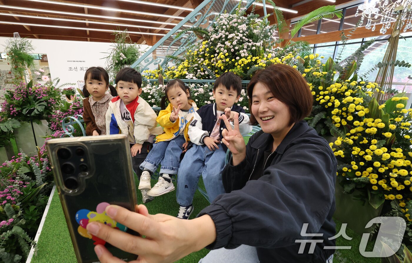 본문 이미지 - 26일 경기 수원시 영통구 영흥수목원에서 열린 ‘제12회 장미·국화 생생전시회’에서 아이들이 다양한 국화와 장미를 보며 가을 정취를 느끼고 있다. 2025.10.26/뉴스1 ⓒ News1 김영운 기자