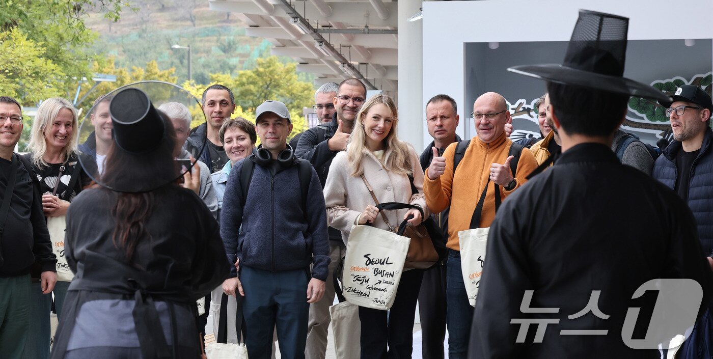 본문 이미지 - 2025 경주 아시아태평양경제협력체&#40;APEC&#41; 정상회의 주간 시작을 하루 앞둔 가운데 26일 경북 경주역에 도착한 러시아 경제인들이 웰컴 키트를 받은 뒤 기념 촬영을 하고 있다. 2025.10.26/뉴스1 ⓒ News1 박지혜 기자