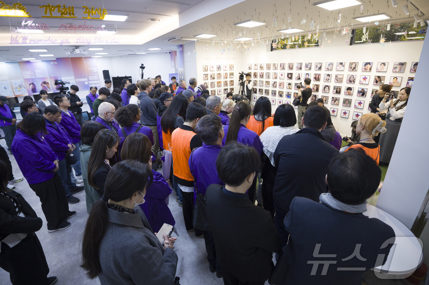 (서울=뉴스1) 김민지 기자 = 26일 오후 서울 종로구 10.29 이태원참사 추모공간 별들의 집에서 열린 외국인 희생자 액자걸기 행사에서 유가족들이 희생자 추모를 위한 묵념을 하 …