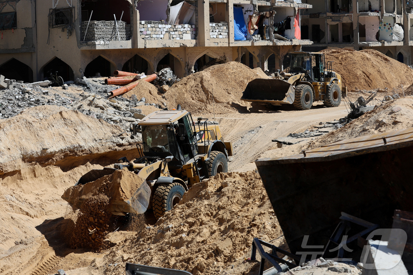 (칸유니스 로이터=뉴스1) 강민경 기자 = 팔레스타인 가자지구 칸유니스에서 18일 중장비들이 시신 수색 작업에 투입되고 있다. 2025.10.18ⓒ 로이터=뉴스1