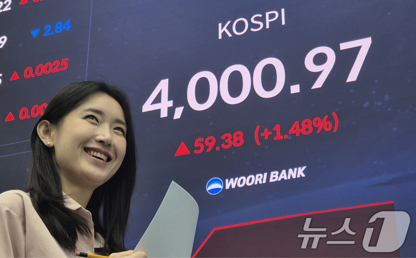(서울=뉴스1) 박지혜 기자 = 코스피지수가 사상 처음 4000선을 돌파한 27일 오전 서울 중구 우리은행 본점 딜링룸에서 직원이 환하게 웃고 있다.코스피 지수는 지난 6월 20일 …
