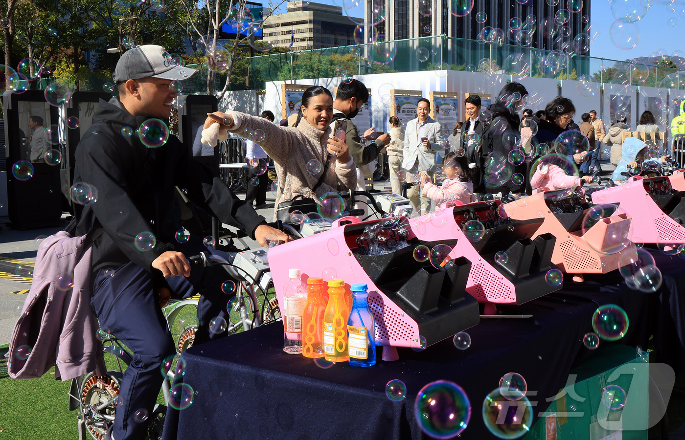 (서울=뉴스1) 김진환 기자 = 27일 오후 서울 종로구 광화문광장에서 열린 제3회 지구하다 페스티벌을 찾은 외국인 관광객들이 자전거 페달을 이용한 발전기로 비눗방울을 만들고 있다 …
