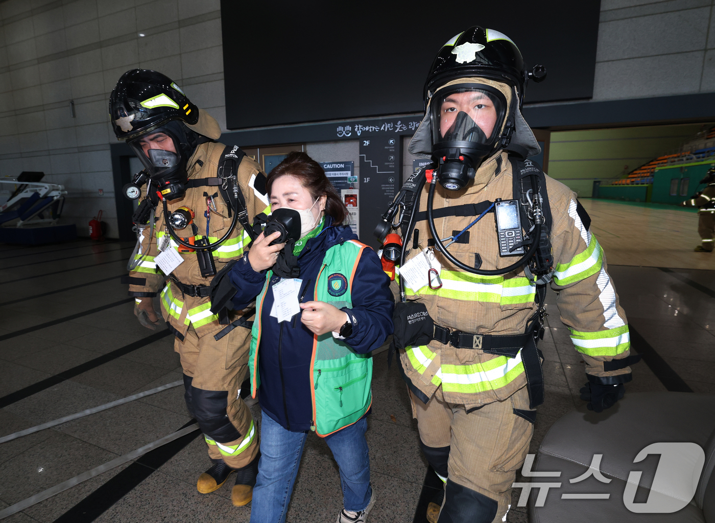 (광명=뉴스1) 김영운 기자 = 27일 오후 경기 광명시 하안동 광명시민체육관에서 열린 '2025년 재난대응 안전한국훈련'에서 훈련 참가자들이 다중밀집시설 대형화재를 가정한 훈련을 …