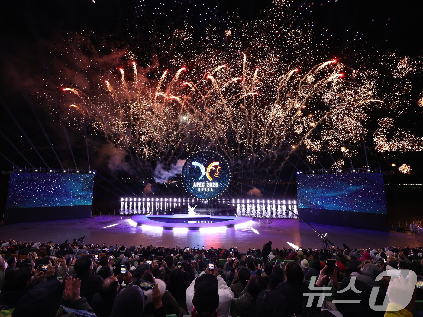 본문 이미지 - 27일 오후 경주 보문 수상공연장에서 열린 ‘APEC 2025 KOREA 기념 보문 멀티미디어쇼–천년의 달’에서 시민들이 ‘천년의 신비, 내일을 날다’를 주제로 펼쳐진 공연을 관람하고 있다. 지름 15m의 대형 원형 구조물을 중심으로 레이저와 LED, 불꽃, 드론이 어우러져 초대형 멀티미디어쇼가 연출됐다. ⓒ News1 박지혜 기자