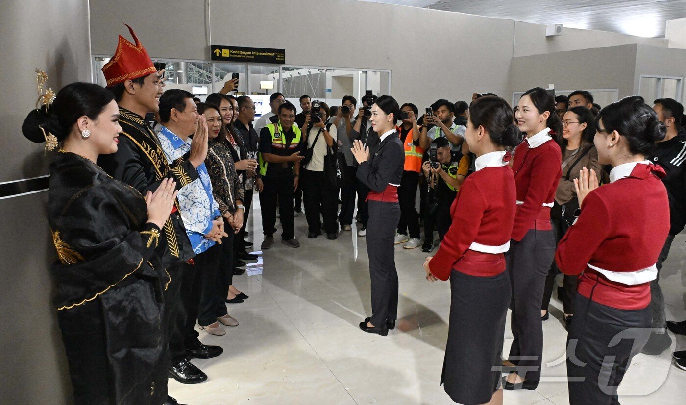 본문 이미지 - 27일&#40;현지시간&#41; 인도네시아 북술라웨시주 마나도 삼 라툴랑이 국제공항에서 열린 이스타항공의 인천-마나도 노선 신규 취항식에서 니 마데 아유 마르티니&#40;Ni Made Ayu Marthini&#41; 인도네시아 관광부 차관&#40;왼쪽 네 번째&#41;을 비롯한 관계자들이 이스타항공 승무원들을 환영하고 있다.   2025.10.27/뉴스1 ⓒ News1 안은나 기자