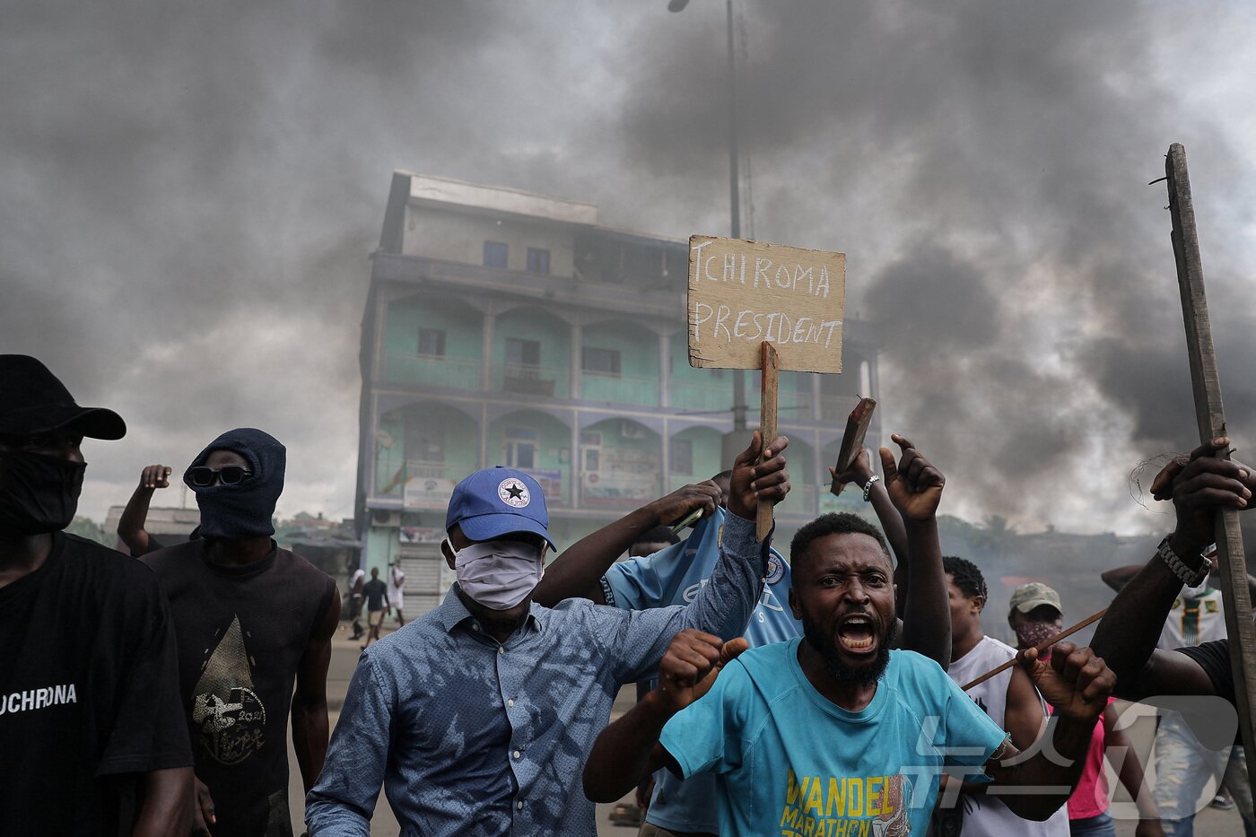 본문 이미지 - 27일(현지시간) 카메룬 헌법위원회가 폴 비야 대통령의 승리를 선언한 뒤, 카메룬 두알라에서 야권 후보인 이사 치로마 바카리의 지지자들이 보안군과 충돌하는 가운데 한 남성이 '치로마 대통령'이라고 쓰인 피켓을 들고 있다. 2025.10.27. ⓒ 로이터=뉴스1 ⓒ News1 윤다정 기자