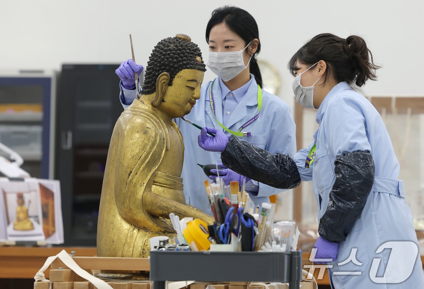 본문 이미지 - 보존과학센터 개관식이 열린 28일 서울 용산구 국립중앙박물관에서 관계자들이 목재실에서 목재불상 건식세척작업을 하고 있다. 2025.10.28/뉴스1 ⓒ News1 권현진 기자