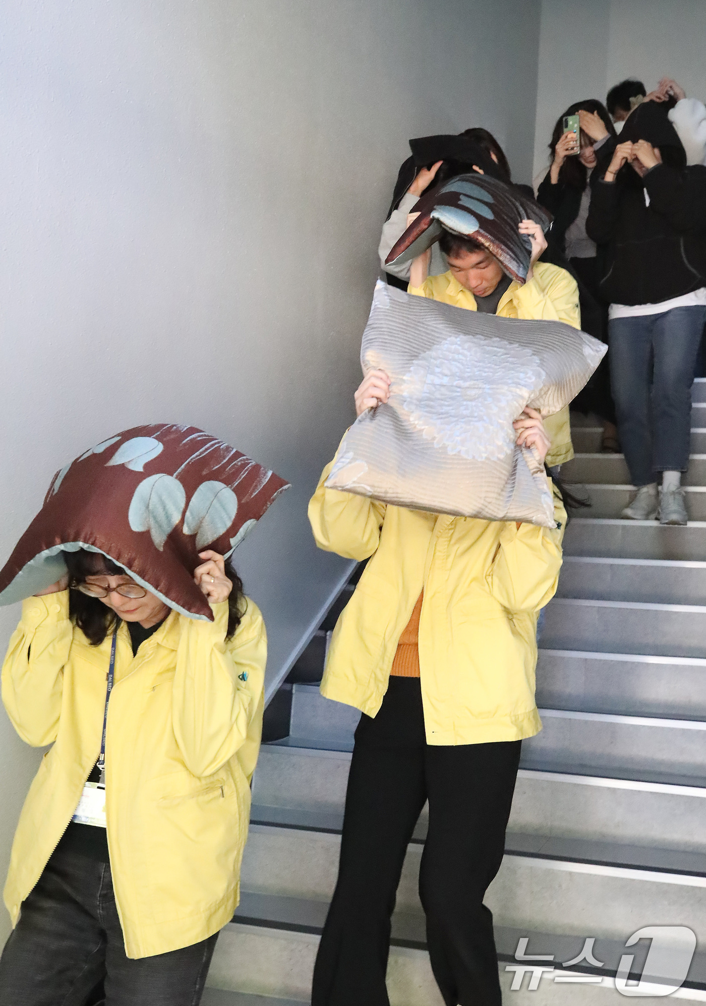 (대구=뉴스1) 공정식 기자 = 28일 오후 대구 달서구청에서 지진 발생 상황을 가정해 열린 대피 훈련에서 구청 직원들이 지진 대피 안내방송에 따라 방석으로 머리를 보호하며 인근 …