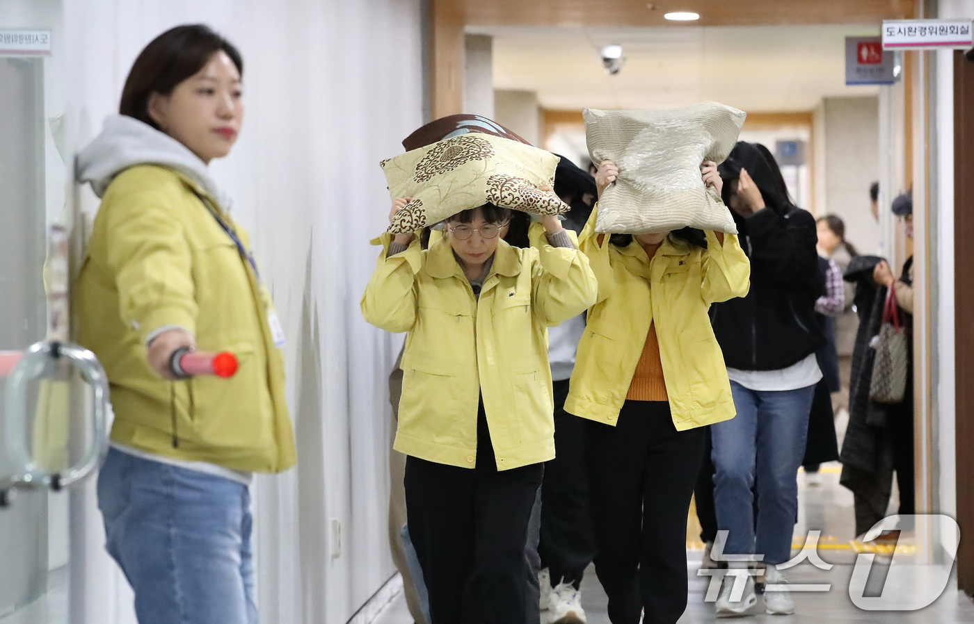 (대구=뉴스1) 공정식 기자 = 28일 오후 대구 달서구청에서 지진 발생 상황을 가정해 열린 대피 훈련에서 구청 직원들이 지진 대피 안내방송에 따라 방석으로 머리를 보호하며 인근 …