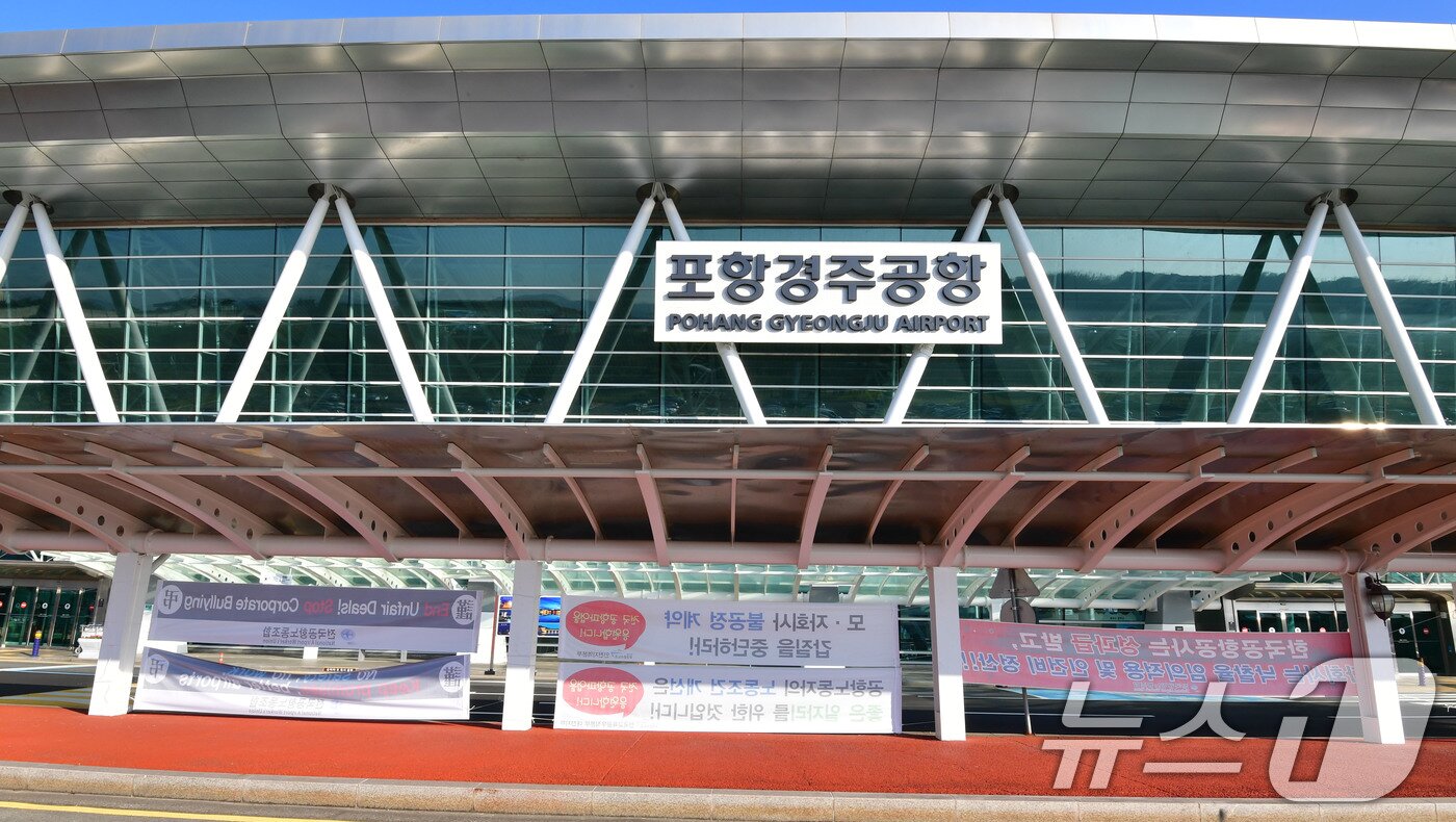 본문 이미지 - 29일 APEC 글로벌 CEO 전용공항인 경북 포항경주공항 입구에 영문으로 된 전국공항 환경미화 주차, 전기 설비 노동자들의 파업 현수막이 걸려있다. 2025.10.29/뉴스1 ⓒ News1 최창호 기자