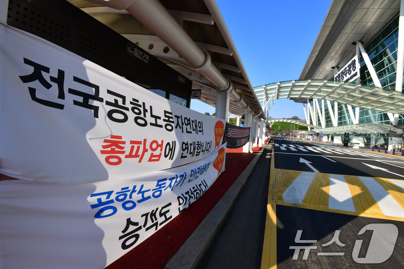 (포항=뉴스1) 최창호 기자 = 29일 APEC 글로벌 CEO 전용공항인 경북 포항경주공항 입구에 전국공항 환경미화 주차, 전기 설비 노동자들의 파업 현수막이 걸려있다. 2025. …