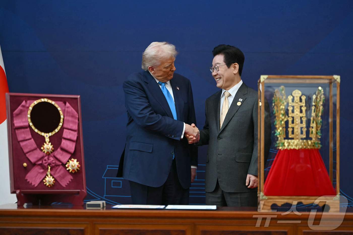 본문 이미지 - 이재명 대통령이 29일 경북 경주박물관에서 열린 한미 공식 환영식에서 도널드 트럼프 미국 대통령에게 무궁화 대훈장 수여와 천마총 금관 모형을 선물한 뒤 악수고 있다. ⓒ AFP=뉴스1