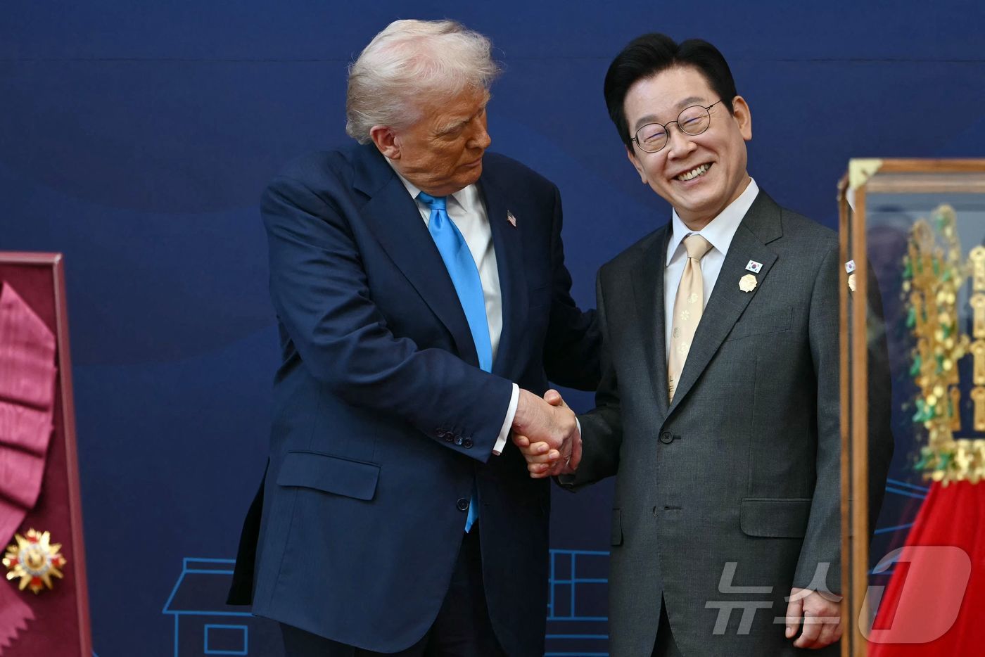 (경주 AFP=뉴스1) 김경민 기자 = 이재명 대통령이 29일 경북 경주박물관에서 열린 한미 공식 환영식에서 도널드 트럼프 미국 대통령에게 무궁화 대훈장을 수여한 후 악수를 하고 …