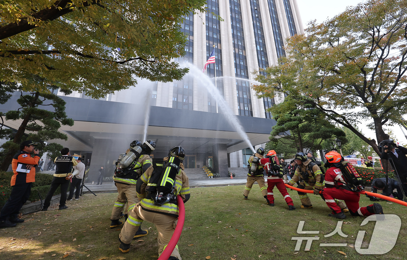 (서울=뉴스1) 김성진 기자 = 29일 서울 종로구 정부서울청사에서 가을·겨울철 화재 대비 재난 예방과 대응을 위해 진행된 민방위 훈련에서 소방대원들이 화재 진압을 하고 있다. 2 …