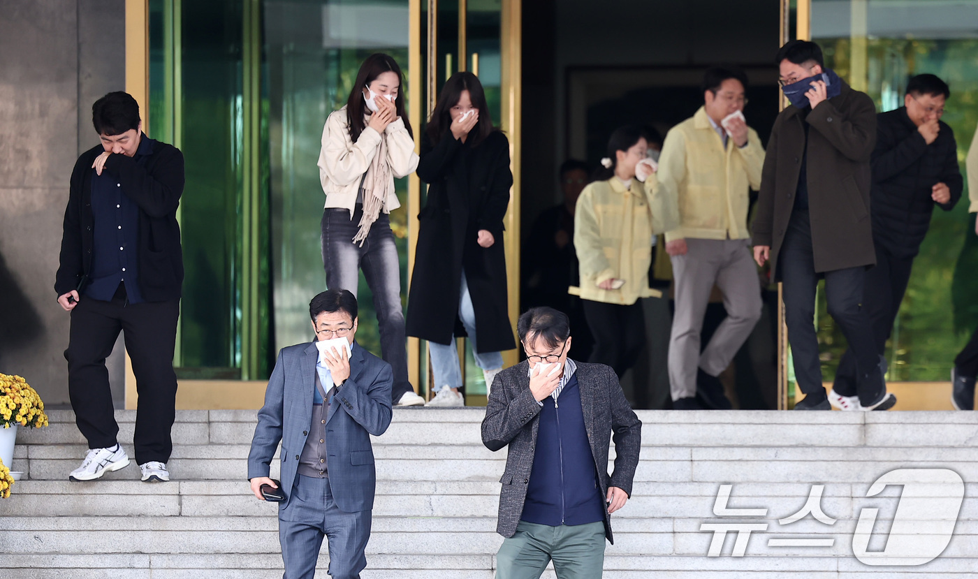 (서울=뉴스1) 김성진 기자 = 29일 서울 종로구 정부서울청사에서 가을·겨울철 화재 대비 재난 예방과 대응을 위해 진행된 민방위 훈련에서 직원들이 입을 가린 채 대피하고 있다. …