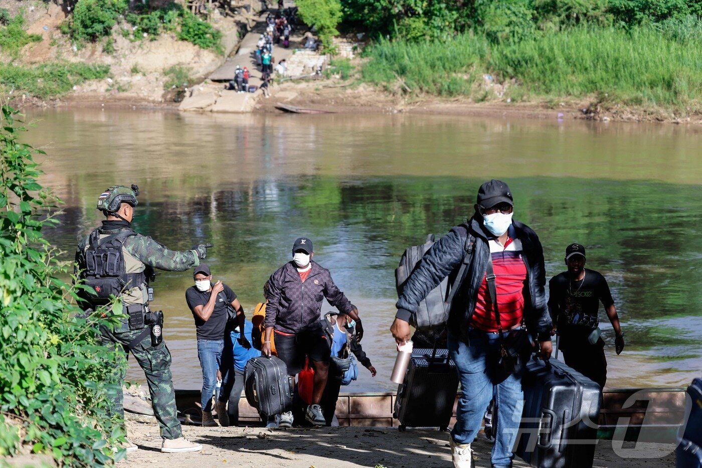 본문 이미지 - 24일&#40;현지시간&#41; 미얀마 KK 파크 단지에서 일하던 근로자들이 짐을 들고 모에이 강을 건너 태국으로 피신하고 있다. 2025.10.24. ⓒ AFP=뉴스1 ⓒ News1 이정환 기자