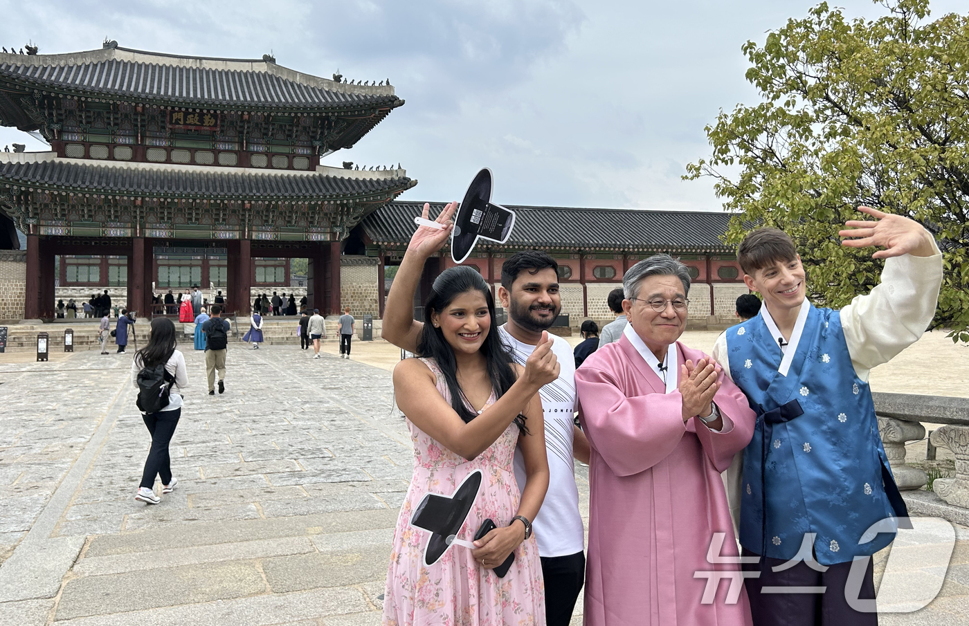 (서울=뉴스1) = 허민 국가유산청장과 프랑스 출신 인플루언서 파비앙 씨가 추석 연휴 첫날인 3일 서울 종로구 경복궁을 찾아 갓 모양 부채 기념품을 든 외국인 관람객들과 기념 촬영 …