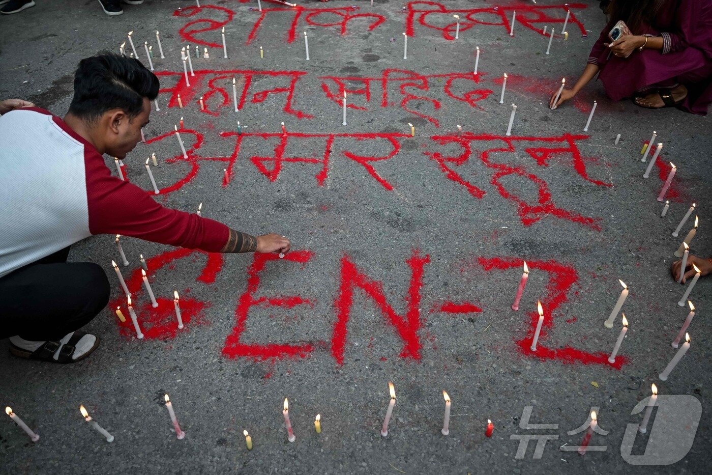 본문 이미지 - 9월 17일&#40;현지시간&#41; 네팔 카트만두에서 시민들이 &#39;순교자들이여 영원하라&#39;라는 문구 옆에 촛불을 밝히고 있다. 이날 카트만두에서는 네팔 전역에서 발생한 시위 도중 숨진 시민들을 기리기 위한 &#39;국가 애도의 날&#39; 묵념 행사가 열렸다. 2025.09.17. ⓒ AFP=뉴스1 ⓒ News1 윤다정 기자