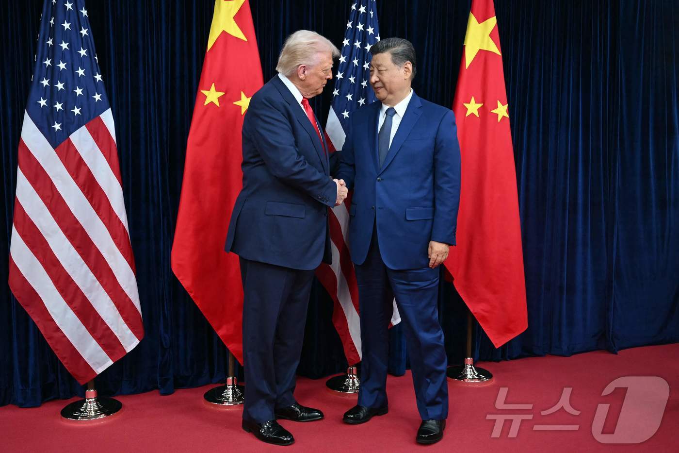 (AFP=뉴스1) 박지혜 기자 = 도널드 트럼프 미국 대통령(왼쪽)과 시진핑 중국 국가주석이 30일 부산 김해국제공항 옆 김해공군기지에서 정상회담 전 악수를 나누고 있다.ⓒ AFP …