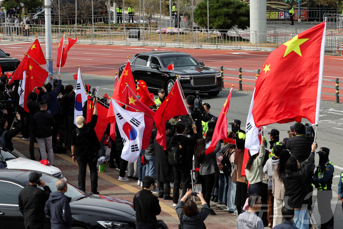 (부산 로이터=뉴스1) 강민경 기자 = 시진핑 중국 국가주석이 30일 부산 김해공항에서 도널드 트럼프 미국 대통령과의 회담을 마치고 떠나는 가운데 사람들이 태극기와 오성홍기를 함께 …