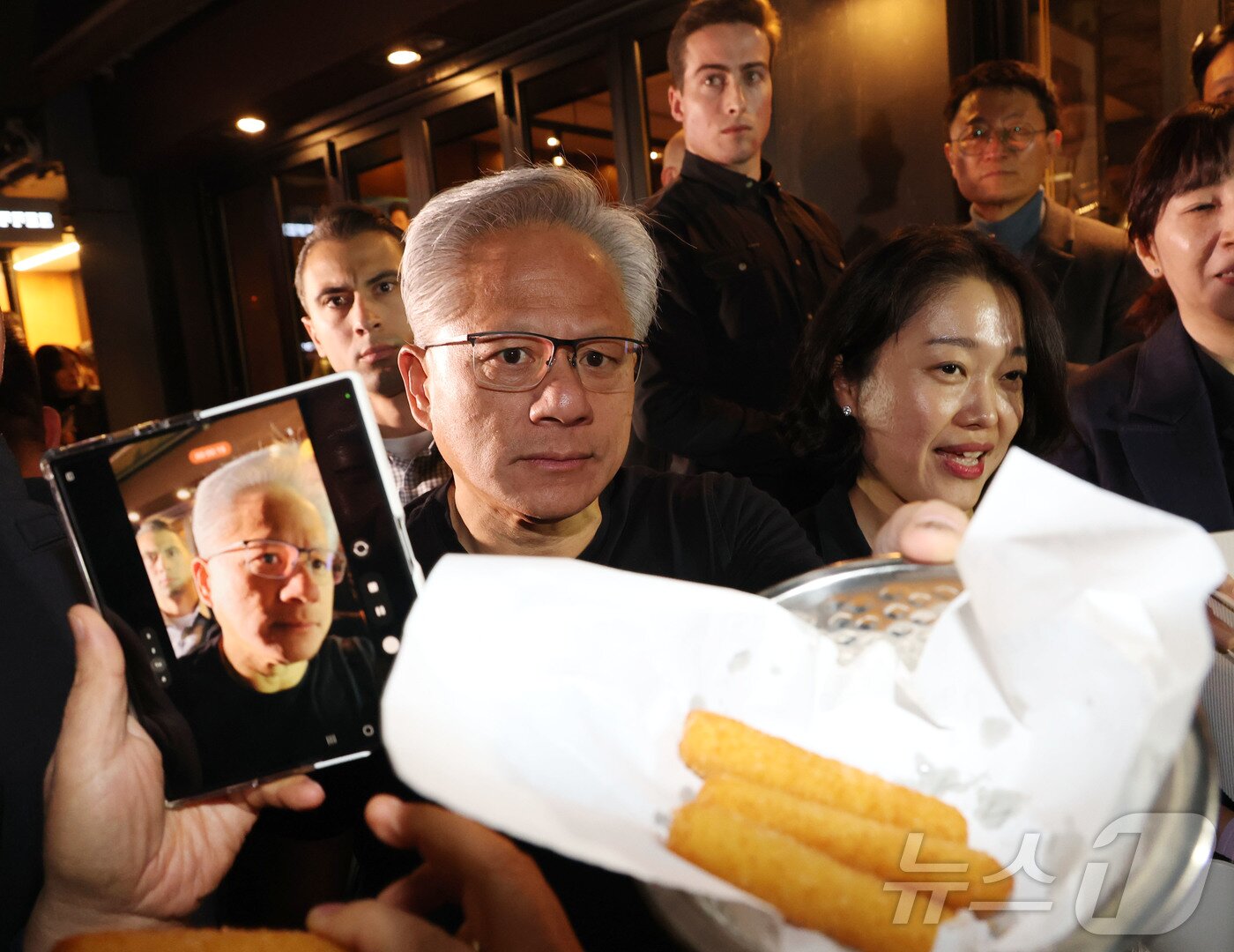 본문 이미지 - 젠슨 황 엔비디아 최고경영자가 30일 이재용 삼성전자 회장, 정의선 현대자동차그룹 회장과 서울 강남구 깐부치킨에서 치킨 회동 중 치즈스틱을 시민들에게 내밀고 있다. (공동취재) 2025.10.30/뉴스1 ⓒ News1 김진환 기자