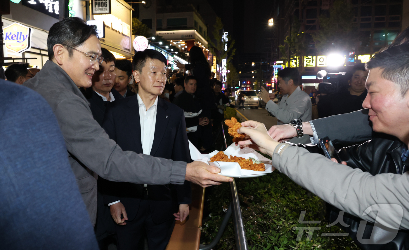 (서울=뉴스1) 김진환 기자 = 이재용 삼성전자 회장이가 30일 서울 강남구 깐부치킨 삼성점에서 젠슨황 엔비디아 최고경영자와 '치맥' 회동 중 시민들에게 치킨을 나눠주고 있다. ( …