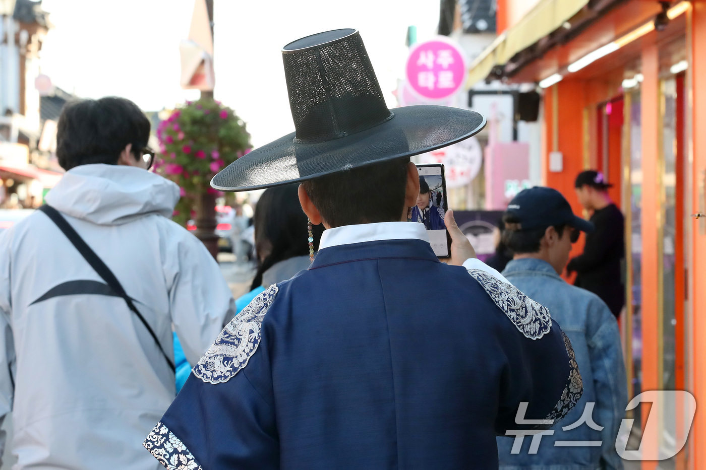 (경주=뉴스1) 공정식 기자 = 31일 오후 경주를 찾은 관광객이 갓을 쓰고 한복 차림으로 황리단길을 걷고 있다.황리단길은 경주 황남동과 서울 이태원 경리단길을 합쳐 ‘황남동의 경 …