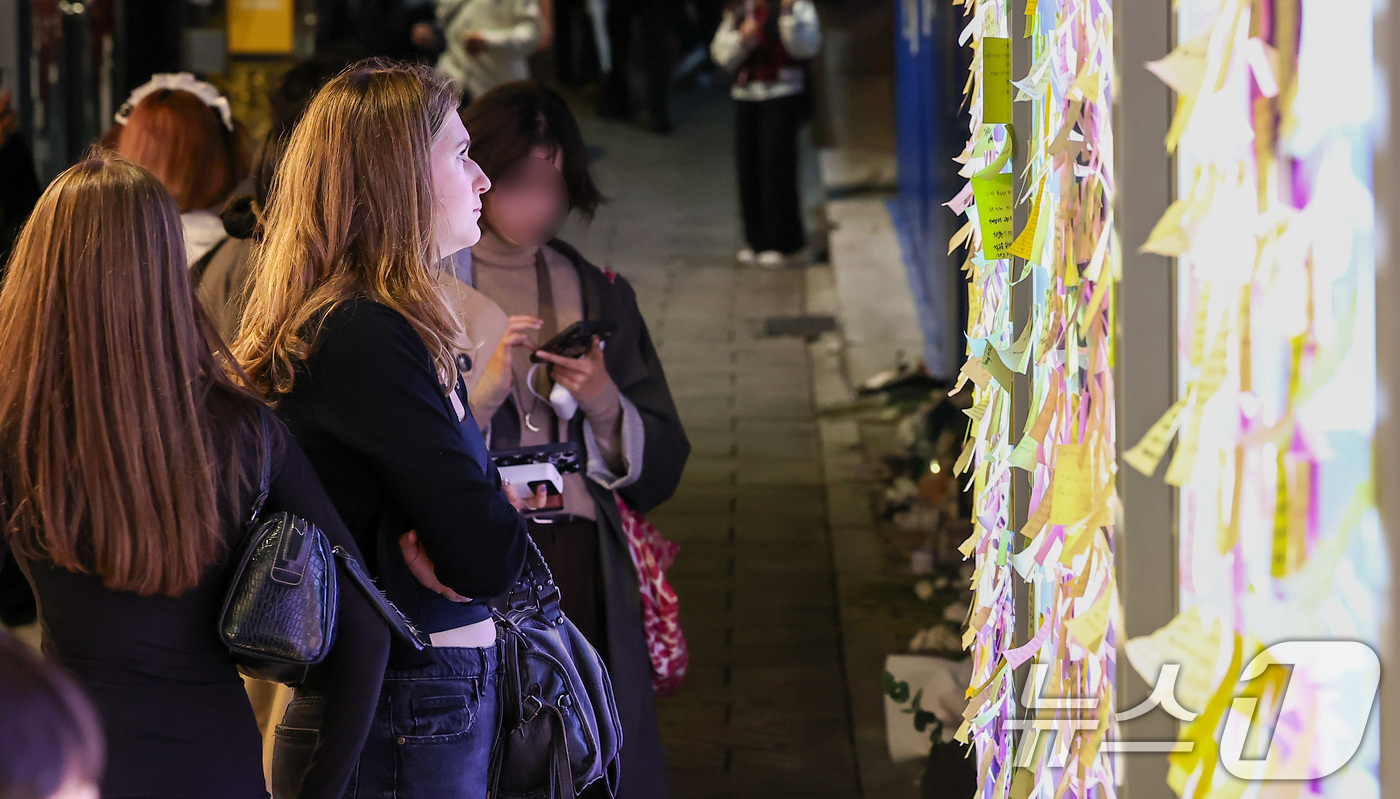 (서울=뉴스1) 김성진 기자 = 핼러윈 데이를 맞은 31일 서울 용산구 이태원 10·29 기억과 안전의 길에서 외국인 관광객이 희생자들을 추모하고 있다. 2025.10.31/뉴스1 …