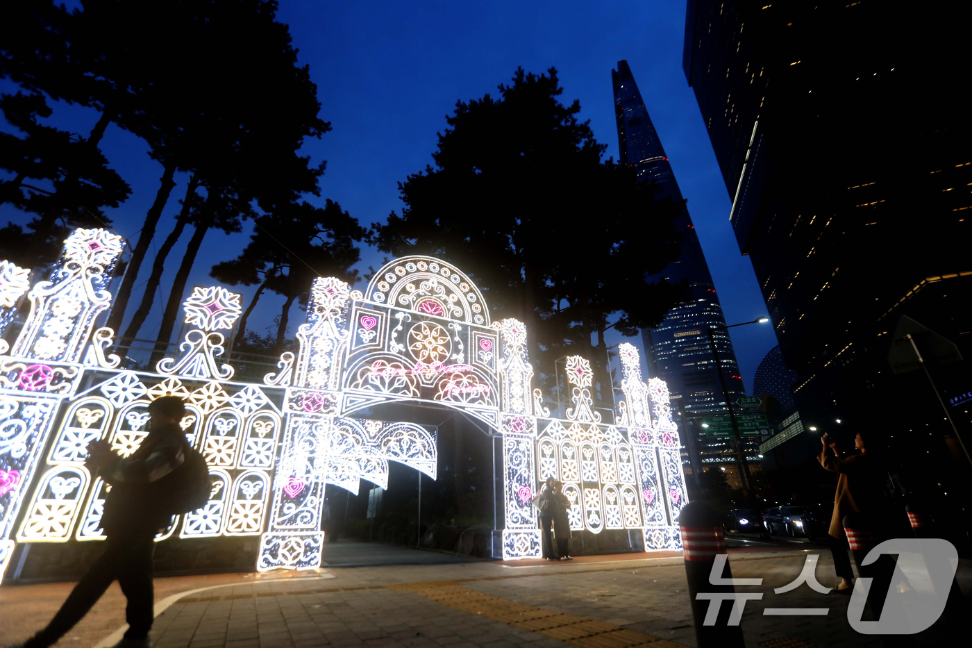 (서울=뉴스1) = 31일 서울 송파구 석촌호수에서 열린 송파 루미나리에 축제룰 찾은 시민들이 화려한 빛 조형물을 감상하고 있다.송파구 석촌호수 일대에서 열리는 '호수의 가을과 겨 …