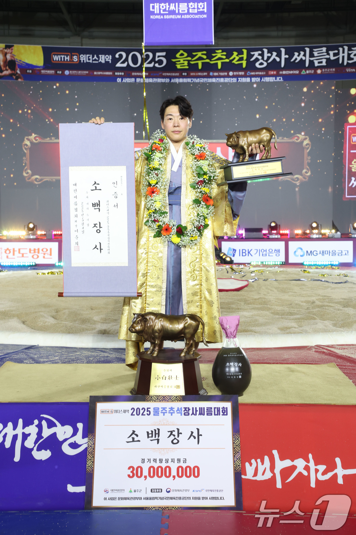 (서울=뉴스1) = 4일 울산광역시 울주군 울주종합체육센터에서 열린 ‘위더스제약 2025 울주추석장사씨름대회’ 소백장사(72kg이하)에 등극한 이완수(증평군청)가 장사인증서와 황소 …