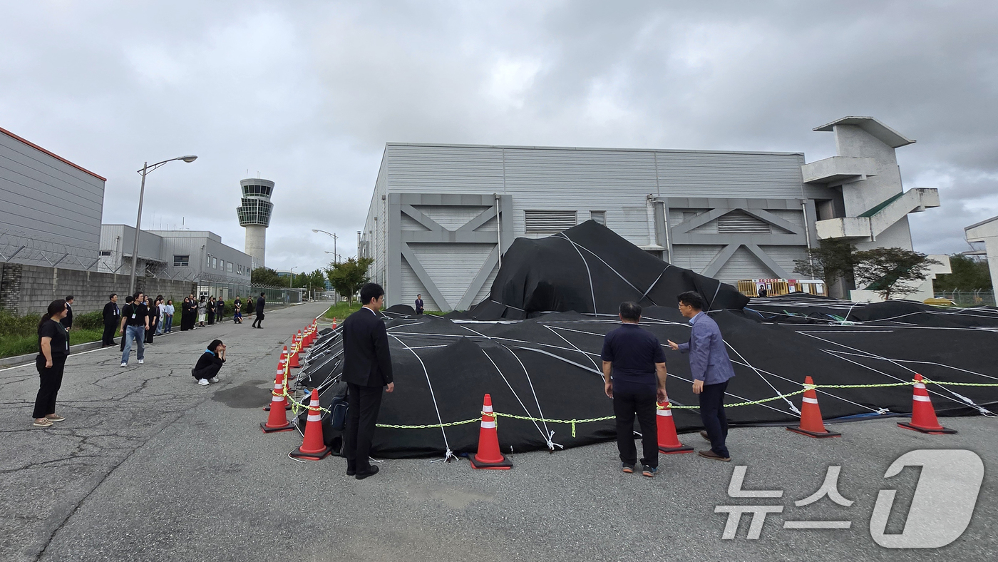 (무안=뉴스1) 이승현 기자 = 4일 전남 무안국제공항에서 12·29 제주항공 참사 유가족들이 격납고 인근에 보관 중인 사고 여객기 꼬리날개를 살피고 있다. (유가족협의회 제공. …