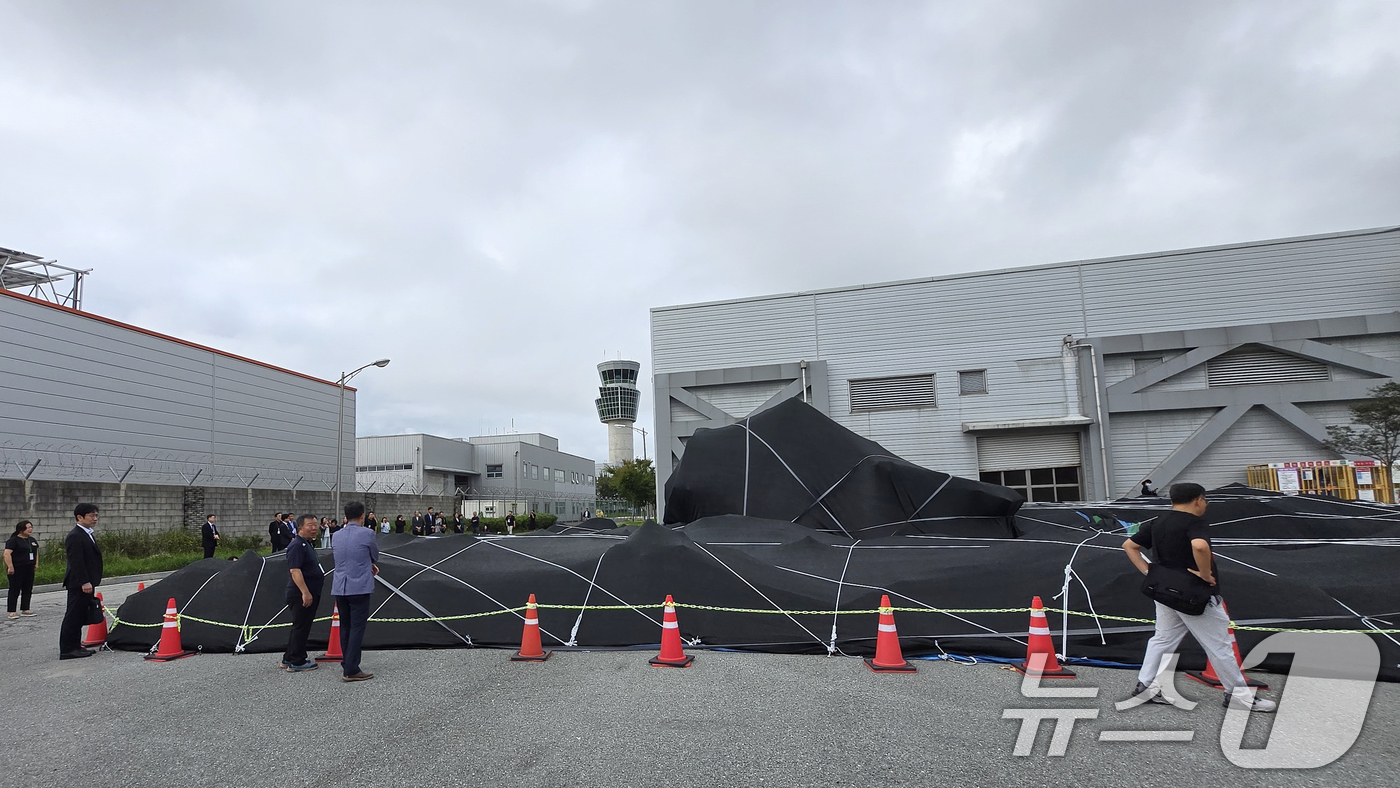 (무안=뉴스1) 이승현 기자 = 4일 전남 무안국제공항에서 12·29 제주항공 참사 유가족들이 격납고 인근에 보관 중인 사고 여객기 꼬리날개를 살피고 있다. (유가족협의회 제공. …