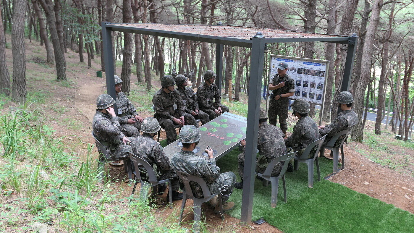 본문 이미지 - 전술훈련을 마친 예비군들이 교관과 함께 훈련 과정을 되짚으며 개선점을 공유하는 사후토의를 진행하고 있다.(육군 2작전사 제공)