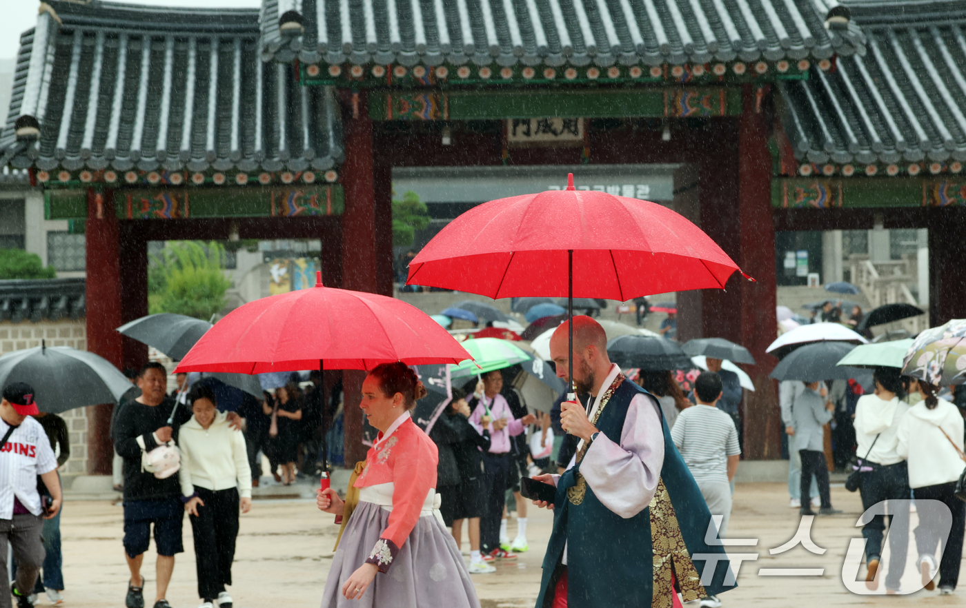 (서울=뉴스1) 김명섭 기자 = 추석인 6일 서울 종로구 경복궁에서 비가 내리는 가운데 시민들과 외국인 관광객들이 나들이를 하고 있다.추석 연휴 기간동안 경복궁, 창덕궁, 덕수궁, …