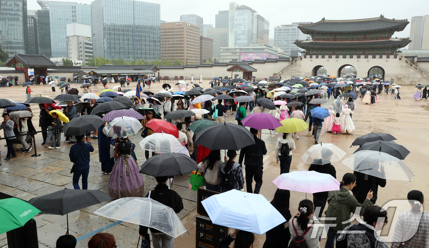 (서울=뉴스1) 김명섭 기자 = 추석인 6일 서울 종로구 경복궁에서 비가 내리는 가운데 시민들과 외국인 관광객들이 나들이를 하고 있다.추석 연휴 기간동안 경복궁, 창덕궁, 덕수궁, …