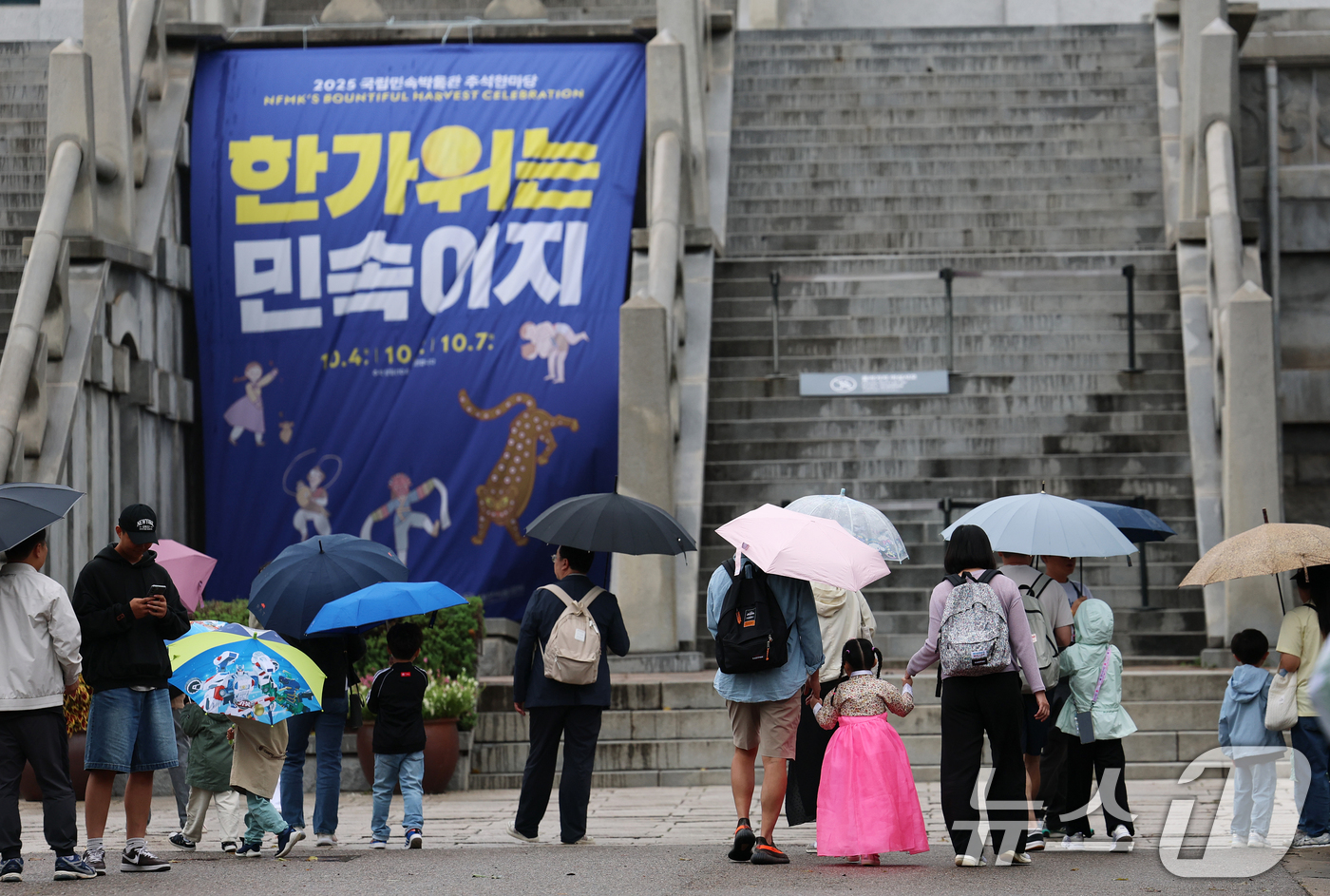 (서울=뉴스1) 오대일 기자 = 민족대명절 추석 이튿날인 7일 오후 서울 종로구 국립민속박물관 추석한마당을 찾은 시민과 관광객들이 우산을 쓴 채 이동하고 있다.  2025.10.7 …