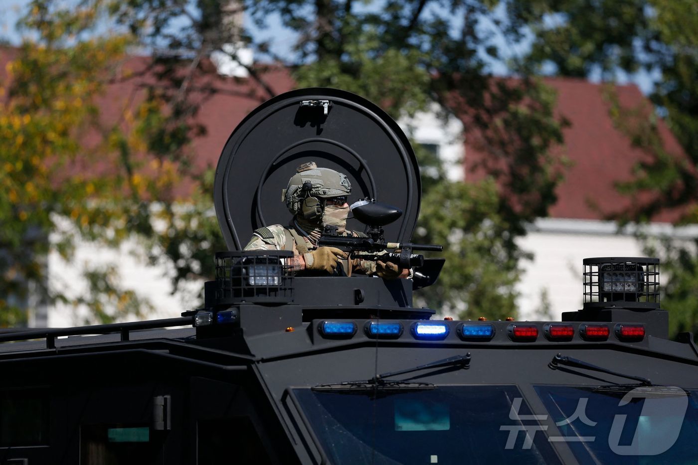 (시카고 AFP=뉴스1) 류정민 특파원 = 지난 4일(현지시간) 일리노이주 시카고에서 한 법 집행 요원이 장갑자에서 시위대를 살피고 있다. 2025.10.04.ⓒ AFP=뉴스1