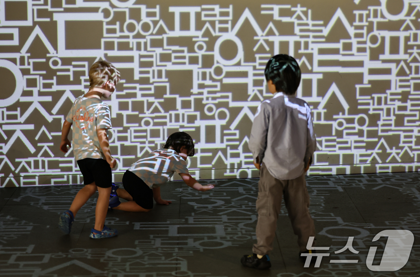 (서울=뉴스1) 김도우 기자 = 한글날을 하루 앞둔 8일 오후 서울 종로구 세종이야기 전시관을 찾은 어린이들이 한글 영상에서 뛰어 놀고 있다. 2025.10.8/뉴스1