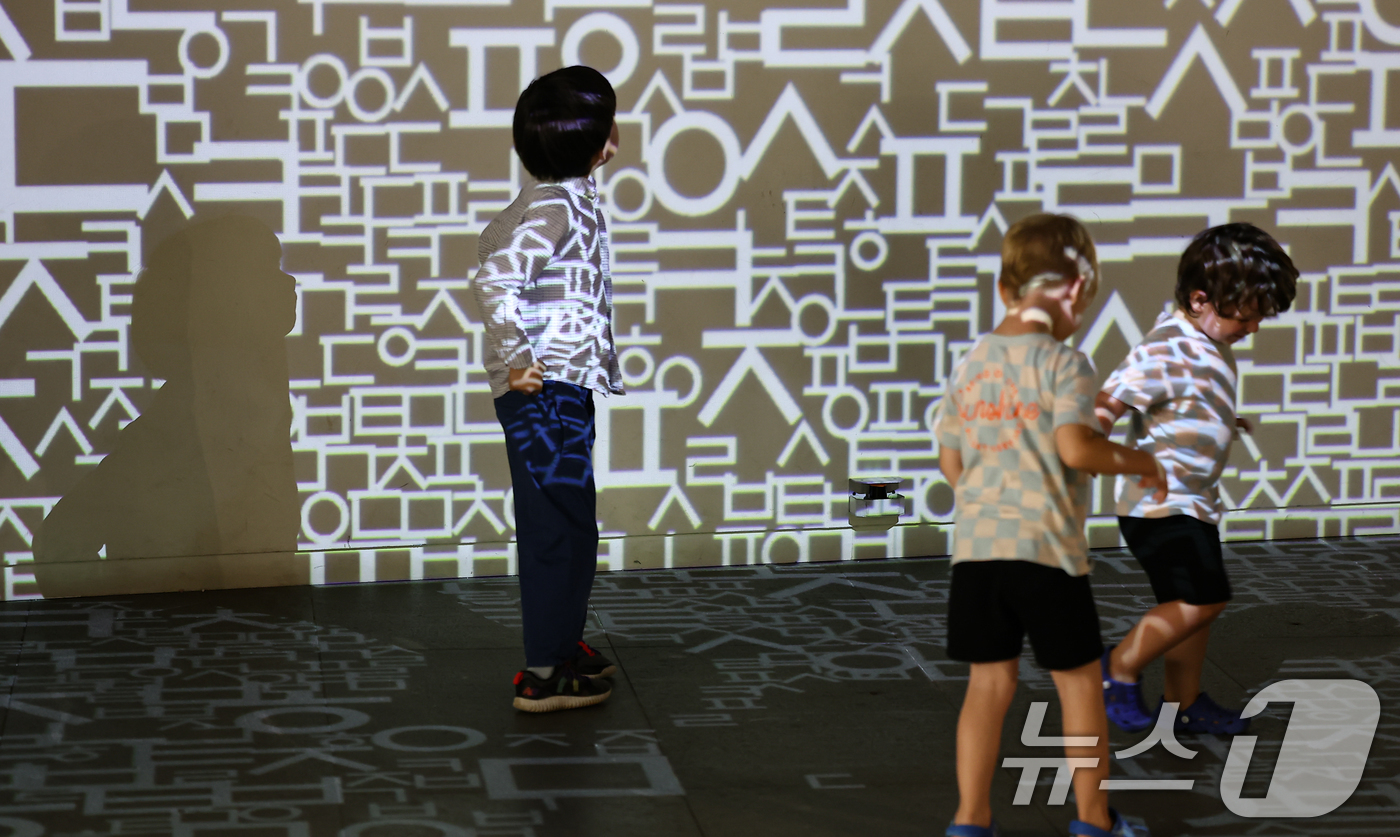 (서울=뉴스1) 김도우 기자 = 한글날을 하루 앞둔 8일 오후 서울 종로구 세종이야기 전시관을 찾은 어린이들이 한글 영상에서 뛰어 놀고 있다. 2025.10.8/뉴스1