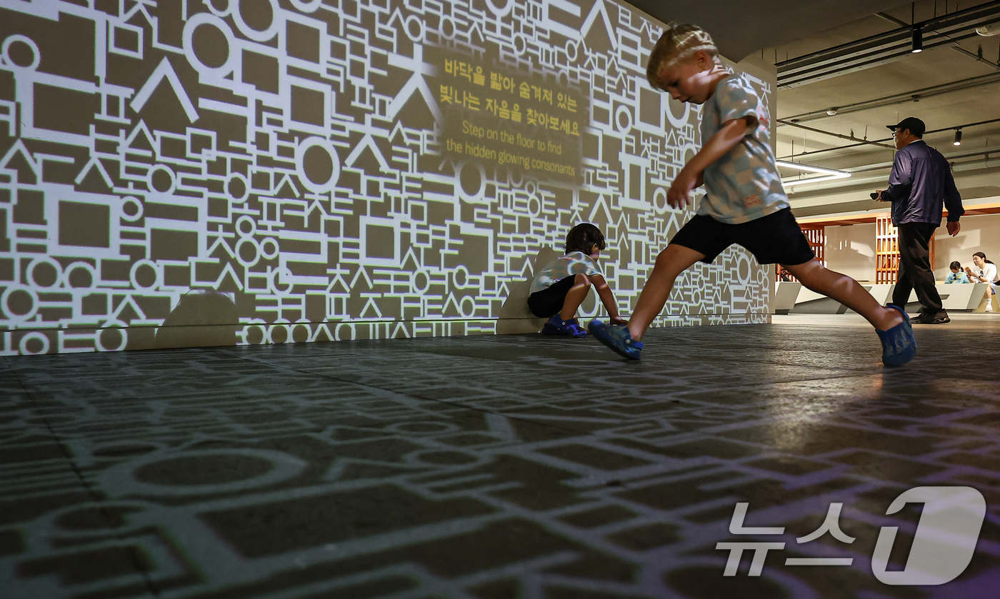 (서울=뉴스1) 김도우 기자 = 한글날을 하루 앞둔 8일 오후 서울 종로구 세종이야기 전시관을 찾은 어린이들이 한글 영상에서 뛰어 놀고 있다. 2025.10.8/뉴스1